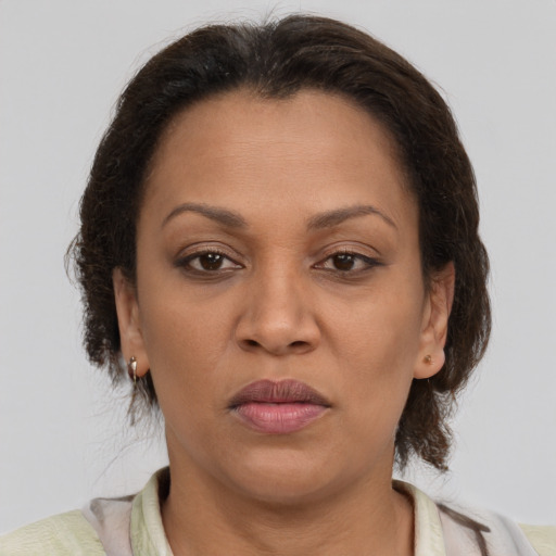 Joyful latino adult female with medium  brown hair and brown eyes