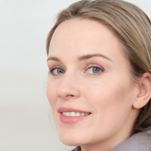 Joyful white young-adult female with medium  brown hair and blue eyes