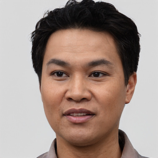 Joyful asian adult male with short  black hair and brown eyes