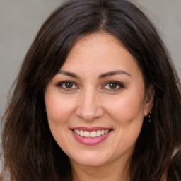 Joyful white adult female with long  brown hair and brown eyes