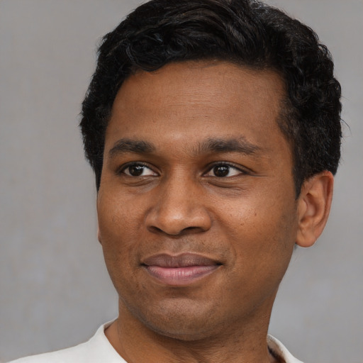 Joyful latino young-adult male with short  black hair and brown eyes