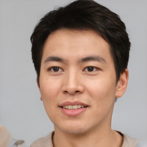 Joyful asian young-adult male with short  brown hair and brown eyes