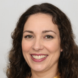 Joyful white adult female with long  brown hair and brown eyes