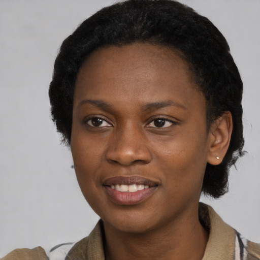 Joyful black young-adult female with short  black hair and brown eyes