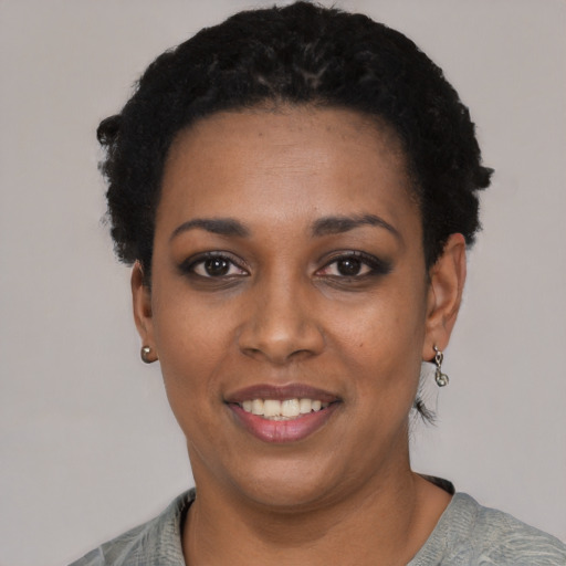 Joyful black young-adult female with short  black hair and brown eyes