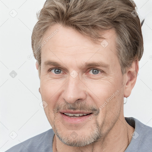 Joyful white adult male with short  brown hair and grey eyes