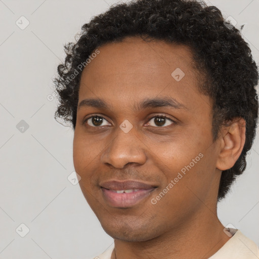 Joyful black young-adult male with short  brown hair and brown eyes