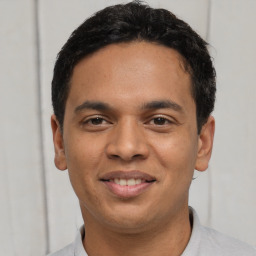 Joyful latino young-adult male with short  black hair and brown eyes