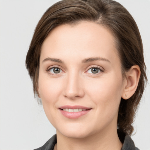 Joyful white young-adult female with medium  brown hair and grey eyes