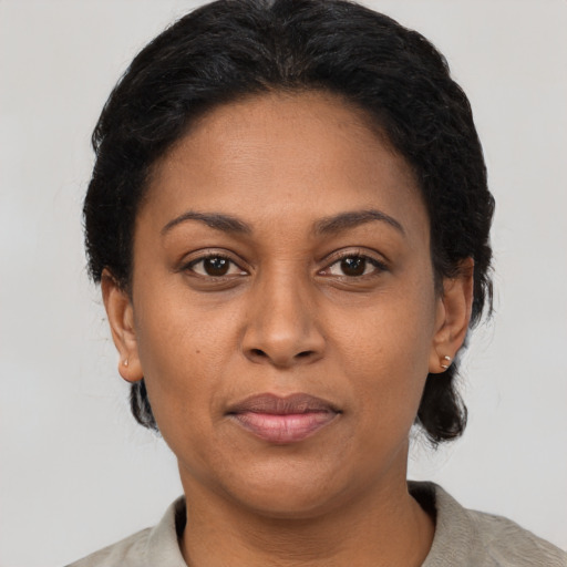 Joyful latino adult female with short  black hair and brown eyes