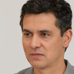 Joyful white adult male with short  black hair and brown eyes