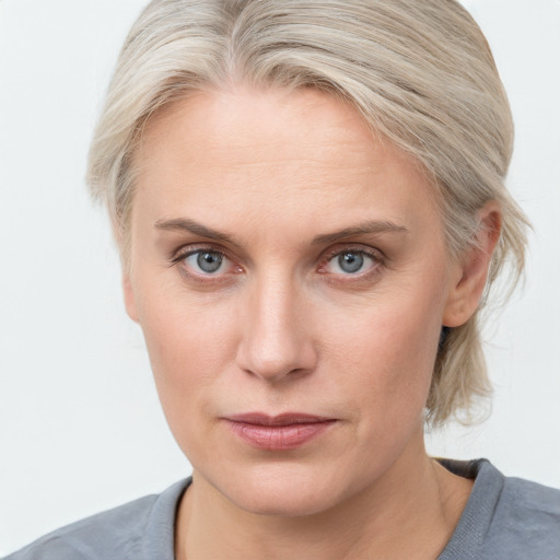 Joyful white adult female with medium  blond hair and blue eyes