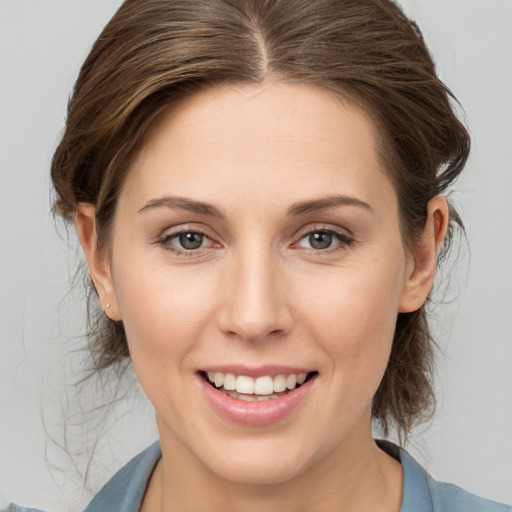 Joyful white young-adult female with medium  brown hair and grey eyes