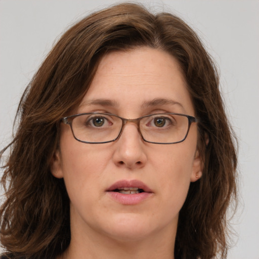 Joyful white adult female with long  brown hair and green eyes