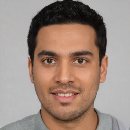 Joyful latino young-adult male with short  black hair and brown eyes