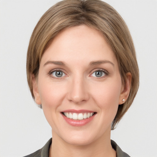 Joyful white young-adult female with medium  brown hair and grey eyes