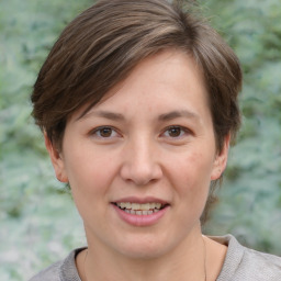 Joyful white young-adult female with short  brown hair and grey eyes