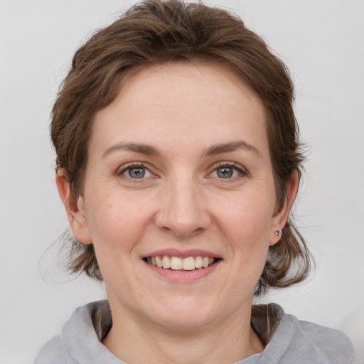 Joyful white young-adult female with medium  brown hair and grey eyes