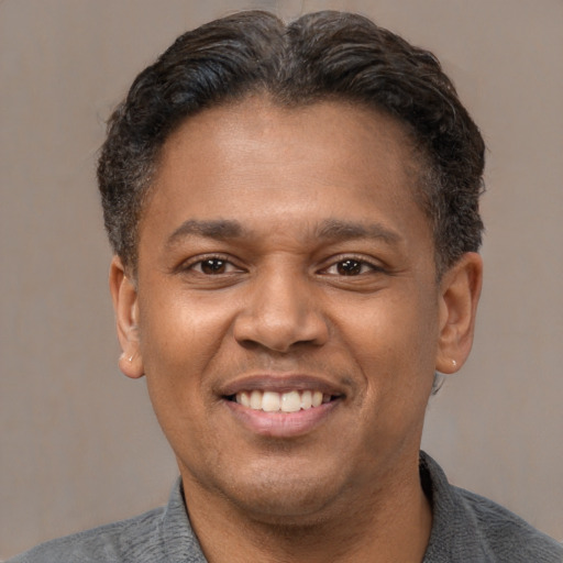 Joyful latino adult male with short  brown hair and brown eyes