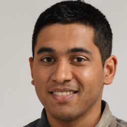 Joyful latino young-adult male with short  black hair and brown eyes