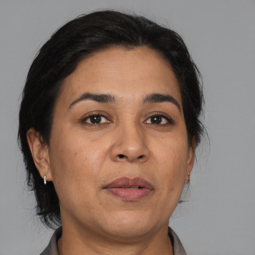 Joyful latino adult female with medium  brown hair and brown eyes