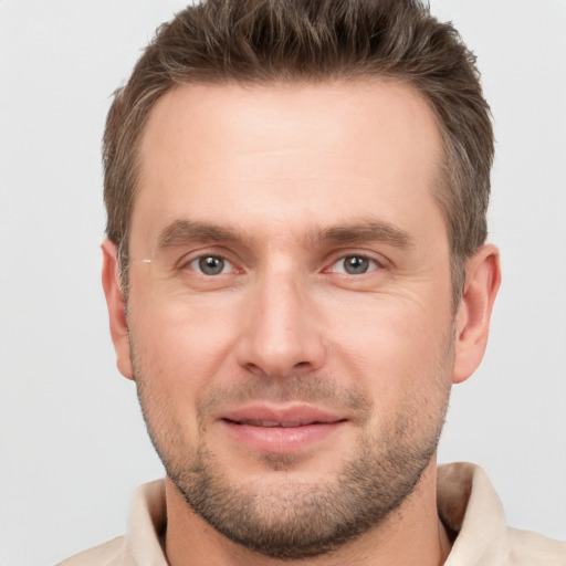 Joyful white young-adult male with short  brown hair and grey eyes