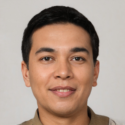 Joyful latino young-adult male with short  black hair and brown eyes