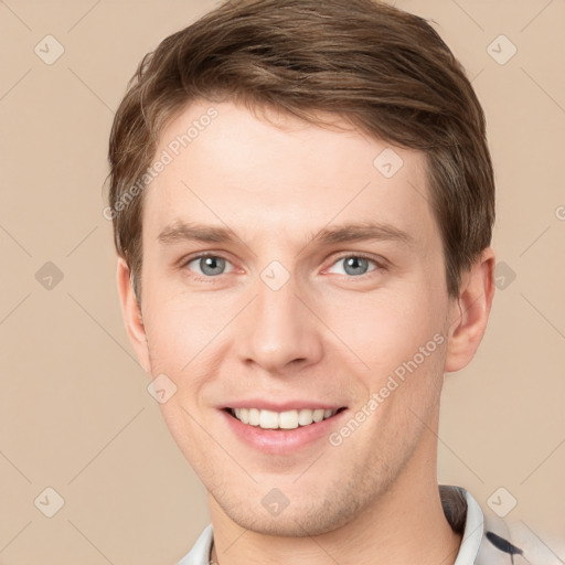 Joyful white young-adult male with short  brown hair and grey eyes