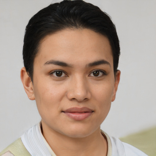 Joyful latino young-adult female with short  black hair and brown eyes