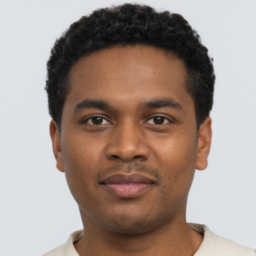 Joyful black young-adult male with short  black hair and brown eyes
