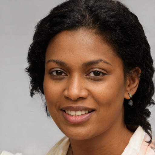 Joyful black young-adult female with medium  brown hair and brown eyes