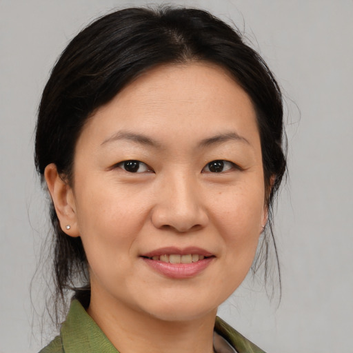 Joyful asian adult female with medium  brown hair and brown eyes