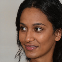 Joyful black young-adult female with long  brown hair and brown eyes