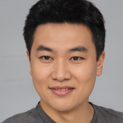 Joyful asian young-adult male with short  black hair and brown eyes