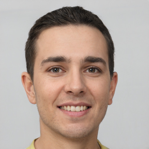 Joyful white young-adult male with short  brown hair and brown eyes