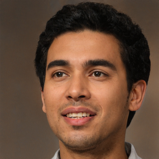 Joyful latino young-adult male with short  black hair and brown eyes