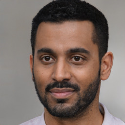 Joyful black young-adult male with short  black hair and brown eyes