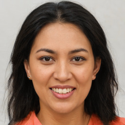 Joyful latino young-adult female with long  brown hair and brown eyes