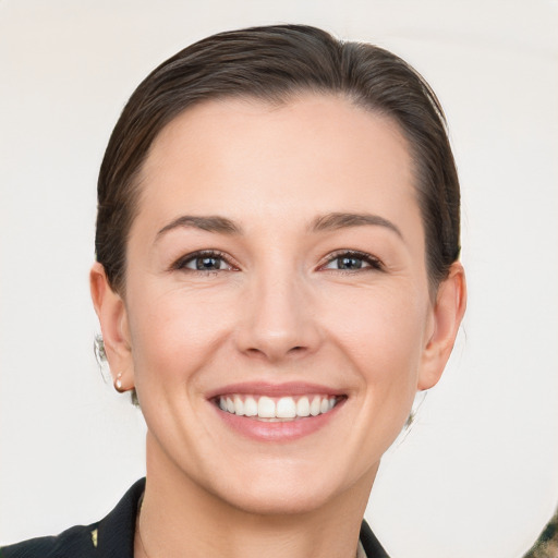 Joyful white young-adult female with medium  brown hair and grey eyes