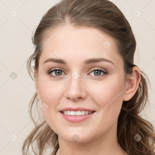 Joyful white young-adult female with long  brown hair and grey eyes