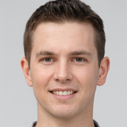 Joyful white young-adult male with short  brown hair and grey eyes