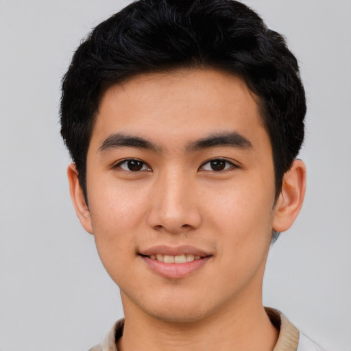 Joyful asian young-adult male with short  black hair and brown eyes