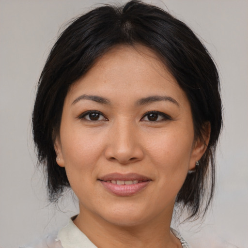 Joyful asian young-adult female with medium  brown hair and brown eyes