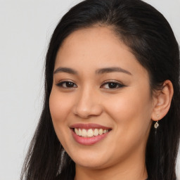 Joyful latino young-adult female with long  brown hair and brown eyes