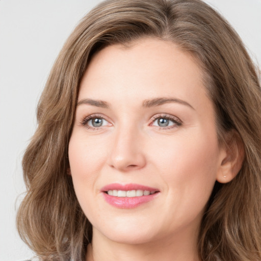 Joyful white young-adult female with long  brown hair and blue eyes