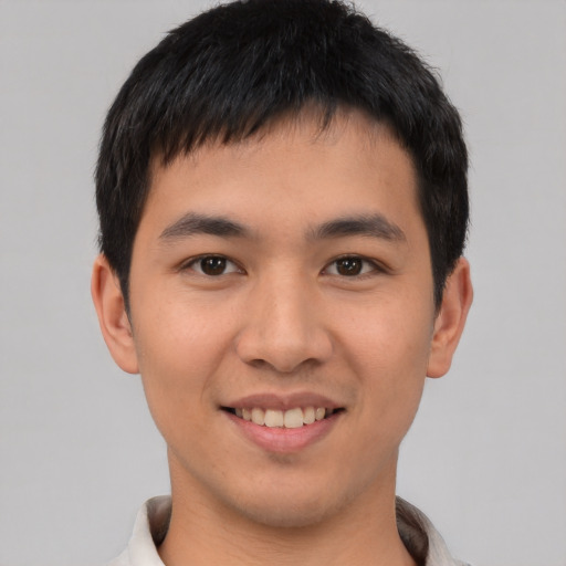 Joyful asian young-adult male with short  black hair and brown eyes
