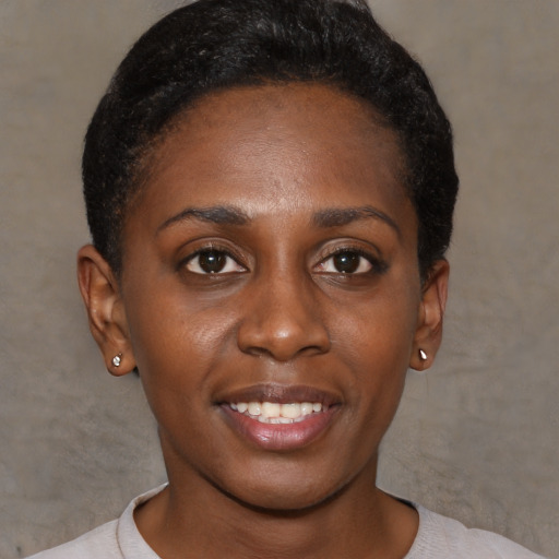 Joyful black young-adult female with short  black hair and brown eyes