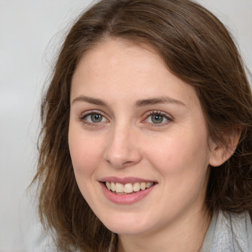 Joyful white young-adult female with medium  brown hair and grey eyes