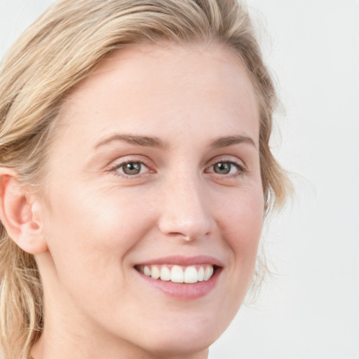 Joyful white young-adult female with medium  brown hair and blue eyes