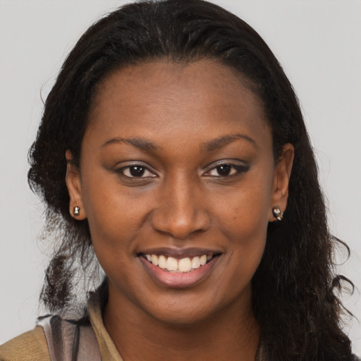 Joyful black young-adult female with long  brown hair and brown eyes